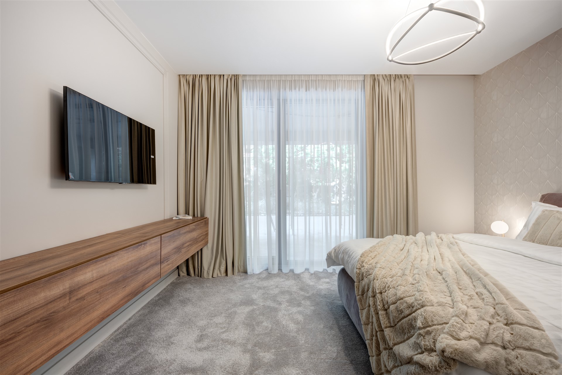 Dormitor modern din showroom ARQA Jolie Village, cu decor minimalist, pat matrimonial confortabil și accente premium.